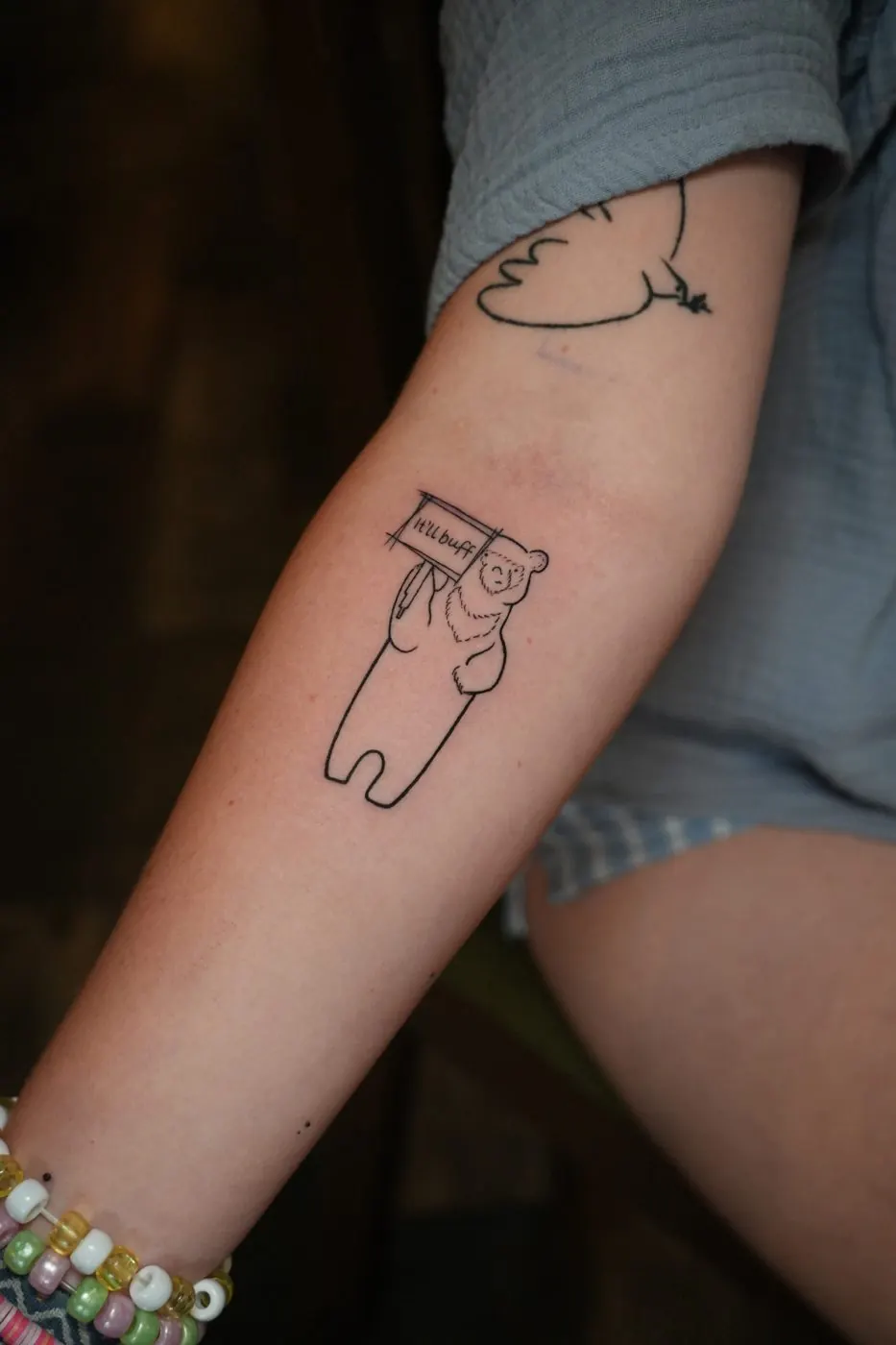 Minimal fine line whale and outline tattoos on an arm