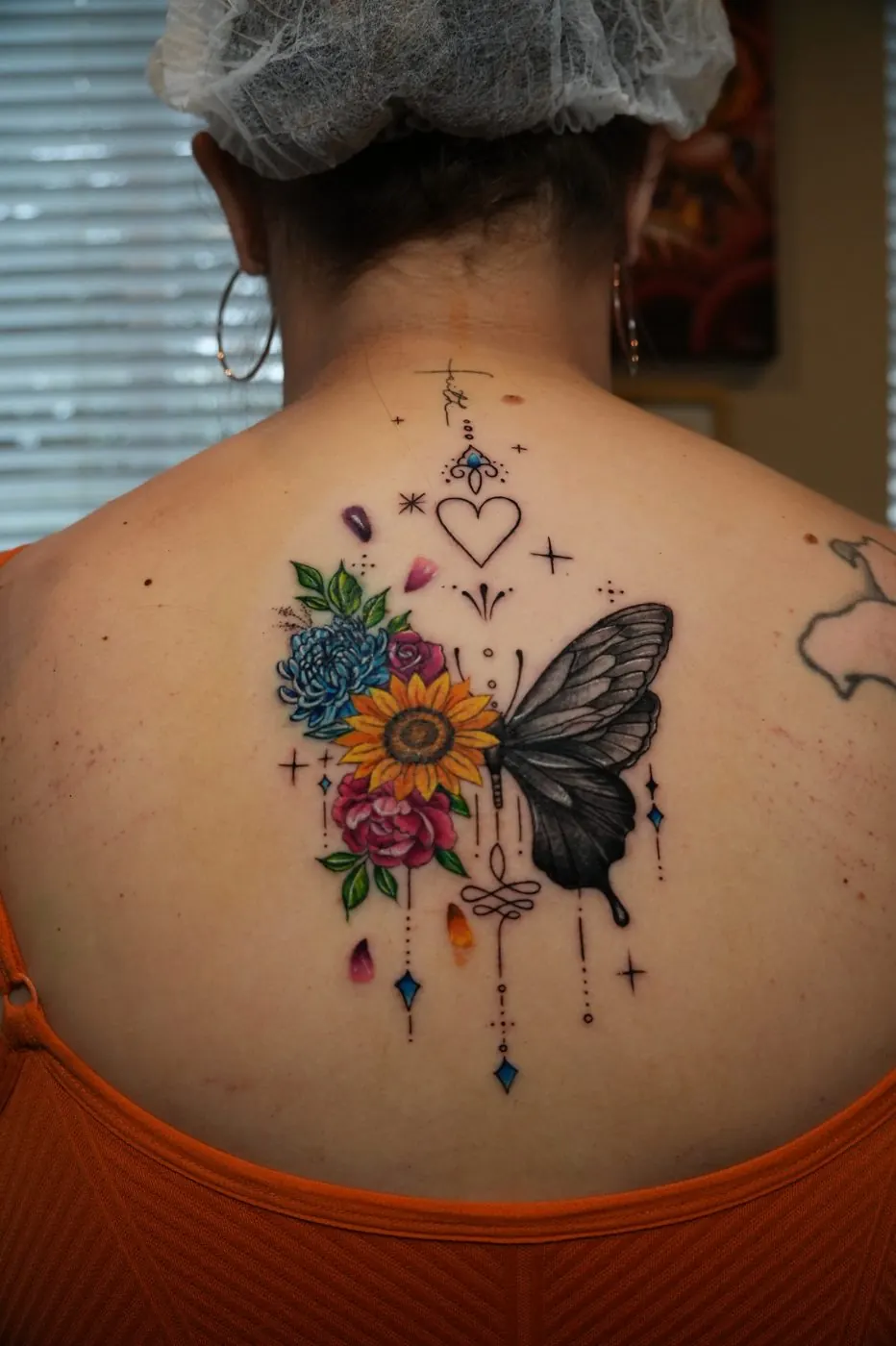 Butterfly and flowers tattoo with jewellery details on the upper back